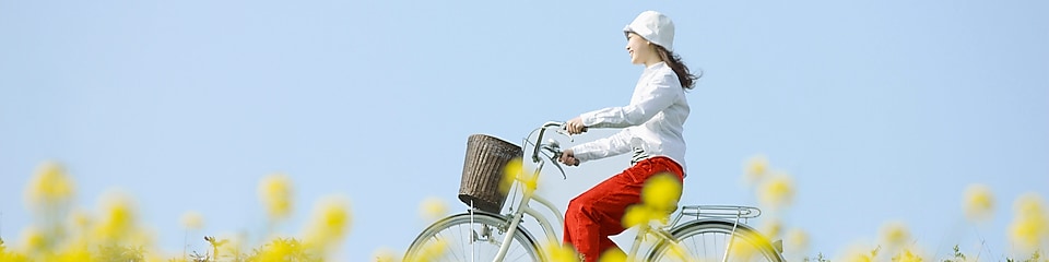 一個年輕女人騎單車穿過夏季的田野